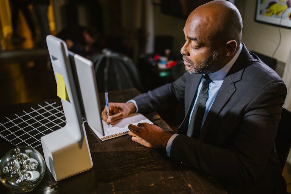 Businessman using a computer at home office during the evening.